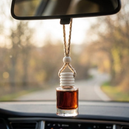 Black Butter car air freshener hanging from a rearview mirror