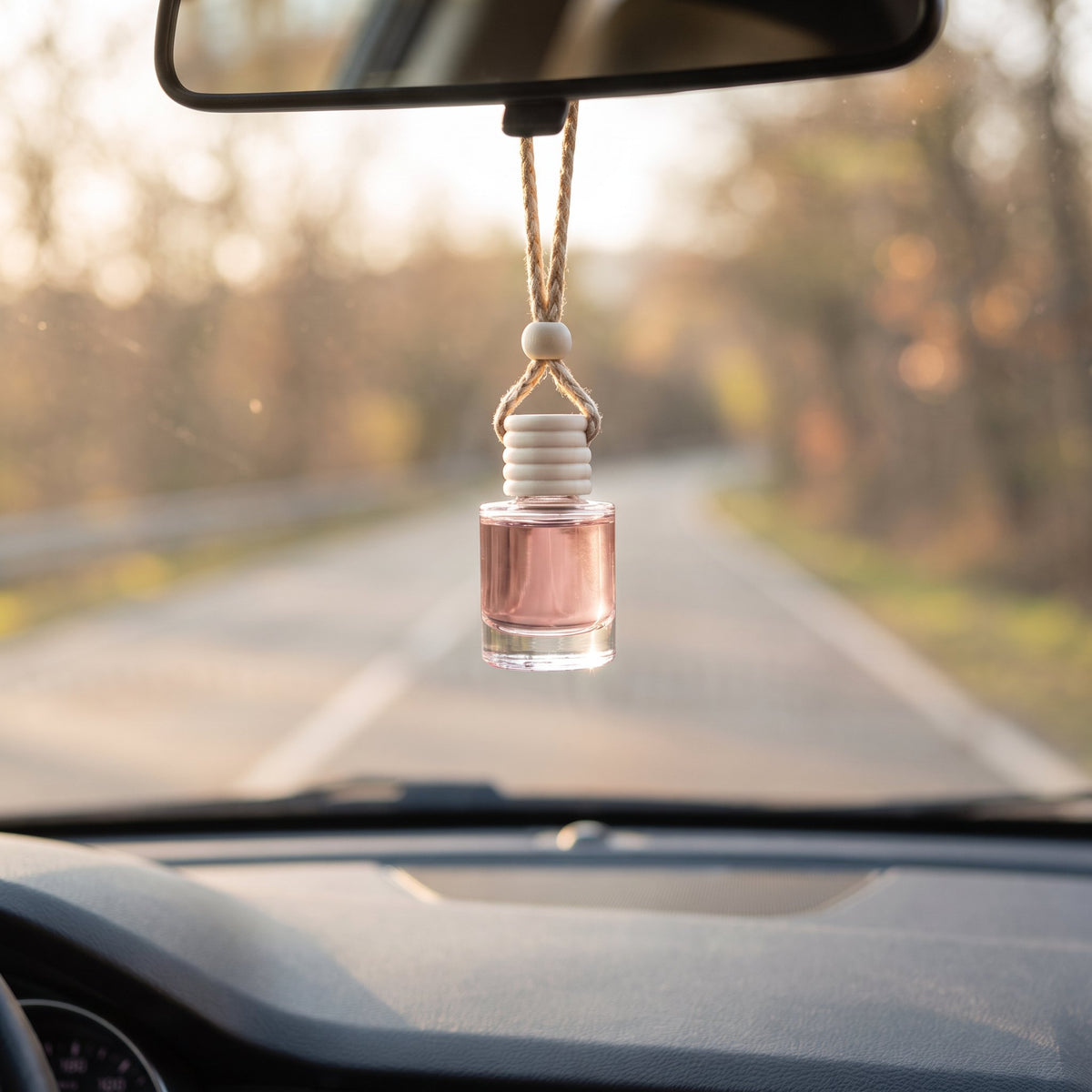 Lick Me All Over car air freshener hanging from a rearview mirror